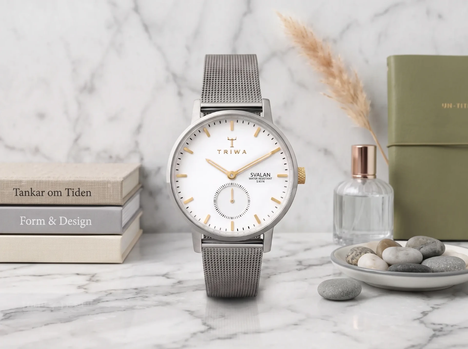 Silver TRIWA Svalan watch with a mesh strap on a marble surface